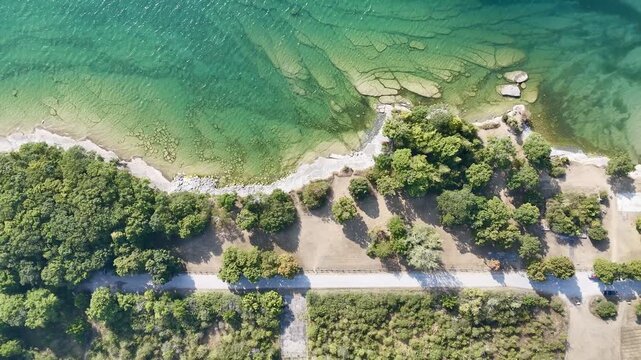 Top view of rocky shoreline and clear green water at Sandbanks Provincial Park, Ontario, Canada on sunny day. g.