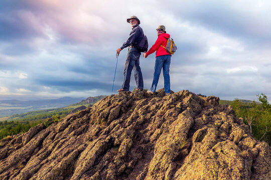 happy mature married couple traveling through the Ural mountains on a summer day