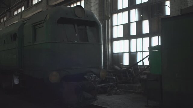Rusty Locomotive In Abandoned Factory. Decaying Train Amid Industrial Ruins Under Bright Sunlight. Media
