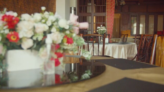 A beautifully decorated restaurant hall for a traditional Chinese engagement ceremony featuring elegant red floral arrangements, gift boxes, and cultural ornaments in a warm, festive atmosphere