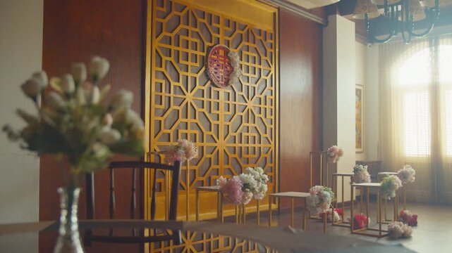 A beautifully decorated restaurant hall for a traditional Chinese engagement ceremony featuring elegant red floral arrangements, gift boxes, and cultural ornaments in a warm, festive atmosphere.