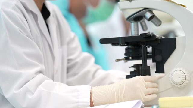 Laboratory microscope scientist technician gloved hand white coat medical research analysis sample specimen test equipment sterile clinical hospital clinic diagnosis biology chemistry medicine bench