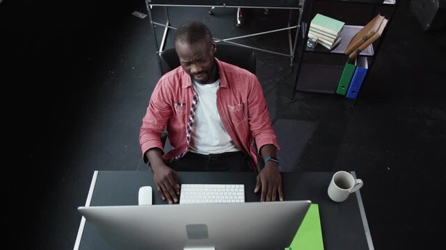 A Focused and Dedicated Professional Engaged in Work at a Modern Desk Featuring a Computer