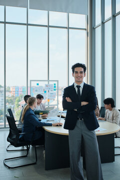 Portrait of confident Hispanic businessman, business CEO president, cheerful, arms crossed, and looks at camera in executive meeting with coworker team in conference office, successful investment.