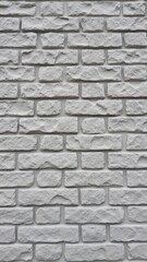 Naklejka premium The image shows a textured brick wall, possibly part of an old building's exterior. The bricks display a faded color with varying tones, suggesting age or weathering.