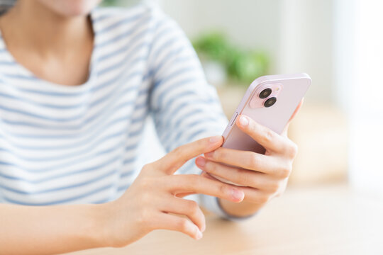 スマホを使う若い女性の手元