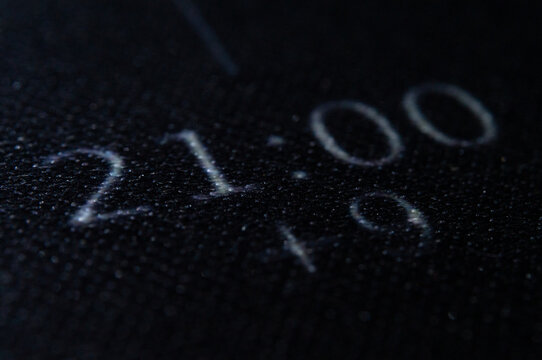 Macro Closeup Selective Focus of '21:00' Digital Time on Dark Textured Surface, Nighttime Theme, Abstract Background