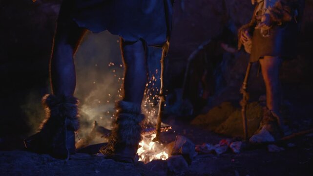 A primitive campfire scene featuring characters engaging in storytelling and rituals