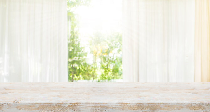 Rustic Living style with white wood table top on blur of curtain window and abstract green from garden with sunlight.Background design