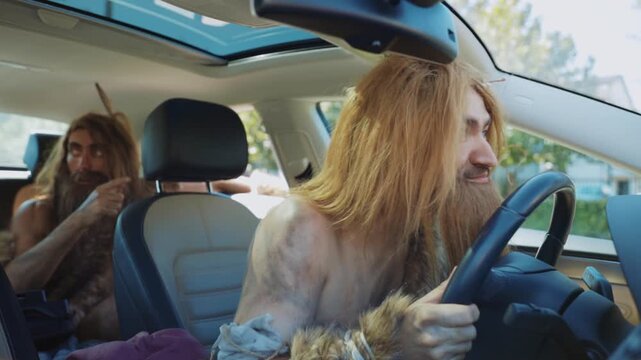 A humorous caveman duo drives a modern car, featuring comical mishaps and playful contrasts