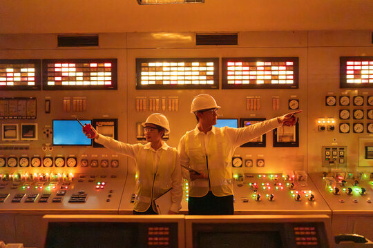 Engineers monitoring control panel in nuclear energy power plant control room, managing systems, ensuring safety and efficiency in global world energy production and industrial operations