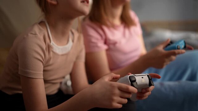 Close up hands holding controllers, intense livingroom duel between two girls, focused thumbs and rapid button presses, warm lamp glow, blanket fort .