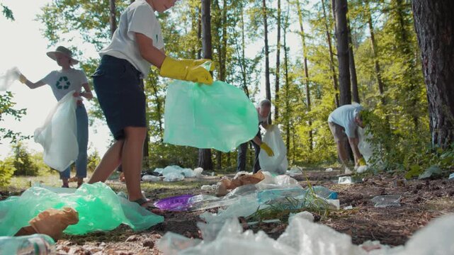 A diverse group of people are actively picking up trash in the woods