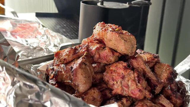 fresh kebab meat pork deliver spread on a plate with foil fork knife Meat, beef ribs in a marinade grilled with salt and spices. Grilled ribs, barbecued meat food