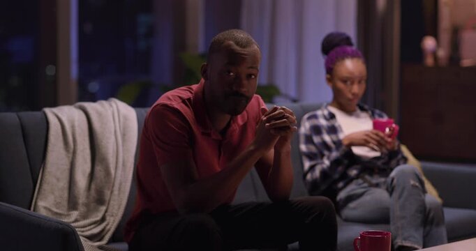 African american negative offended couple of sad boyfriend and girlfriend sitting separately on sofa thinking about divorce. Relationship problems.