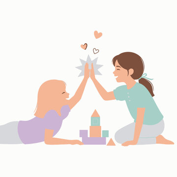Two Happy Young Girls Playing Together with Blocks and Giving a High Five
