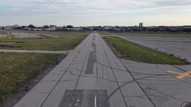 A forward-moving aerial shot taking off from the closed runways of Buttonville Airport, rising to reveal the busy Highway 404 and industrial landscape in Markham, Ontario
