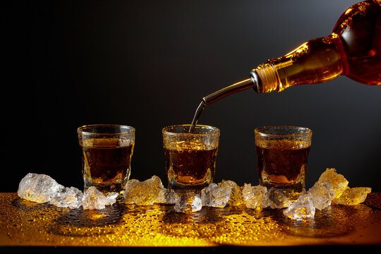 Whiskey pours from bottle to glass.