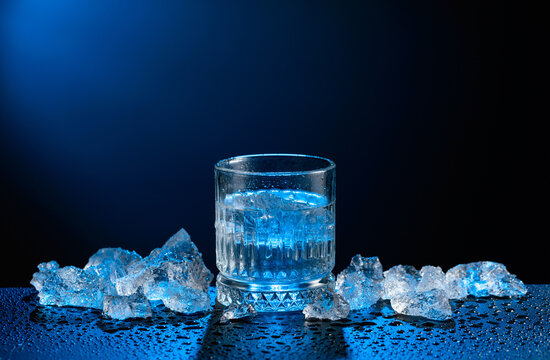 Vodka and crushed ice on a black table.