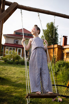 happy child on swing in village of Countryside during summer holidays