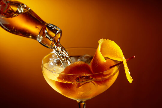 Old-fashioned cocktail garnished with orange peel.