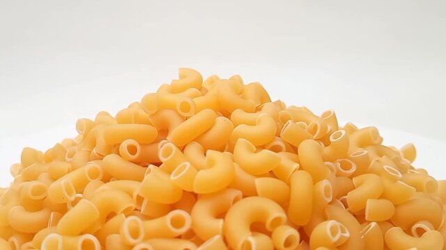 A Pile Of Elbow Macaroni Pasta Rotating on White Background, Uncooked Elbow Macaroni Pasta Ingredient