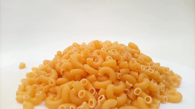 Elbow Macaroni Pasta Dropping on White Background, Uncooked Elbow Macaroni Pasta Ingredient