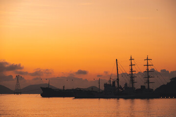 Naklejka premium Silhouettes of Vietnamese warships military ships in port at sea in morning at sunrise in harbor in Nha Trang in Vietnam