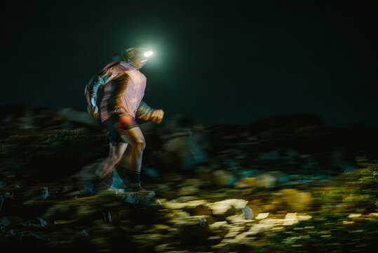 Motion blur of an athlete trail running in the dark with a headlight