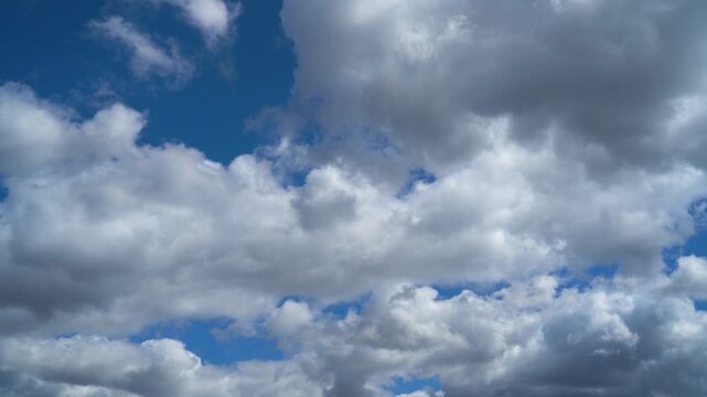 Light clouds move across a clear blue sky on a sunny day.