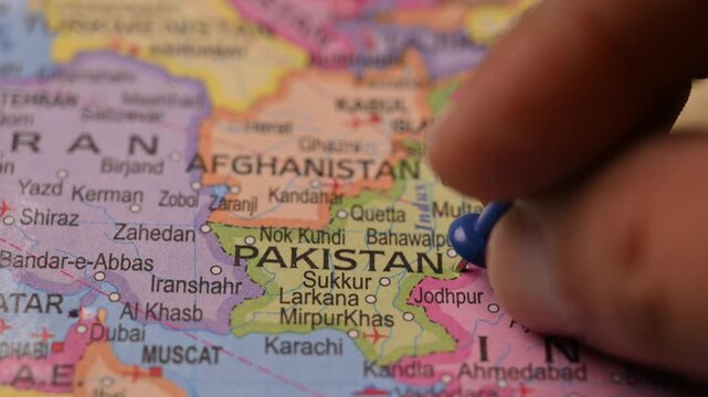 Close-Up World Map Shot Featuring Blue Pin Highlighting Pakistan Pointed by Hand 4K 60fps