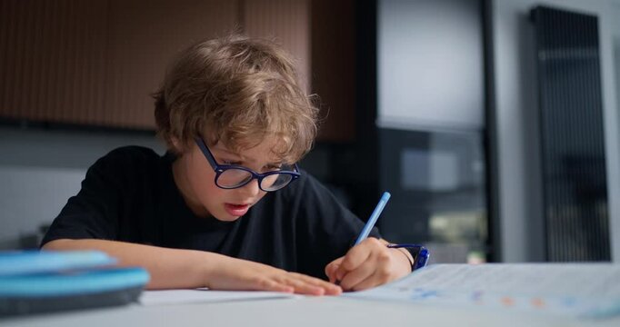 Young Boy Listens Intently And Completes His Worksheet With Precision During Evening Study Session