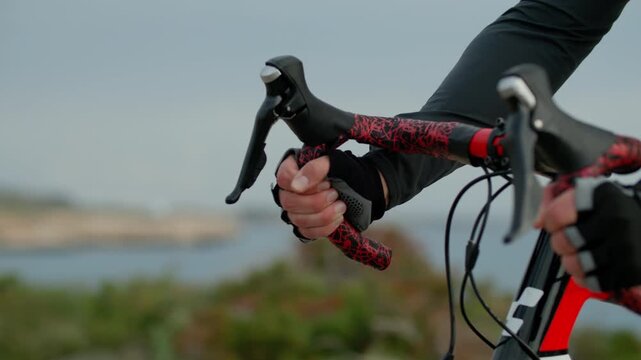 Close-up of male hands on bicycle handlebars while riding. Cycling and healthy lifestyle.