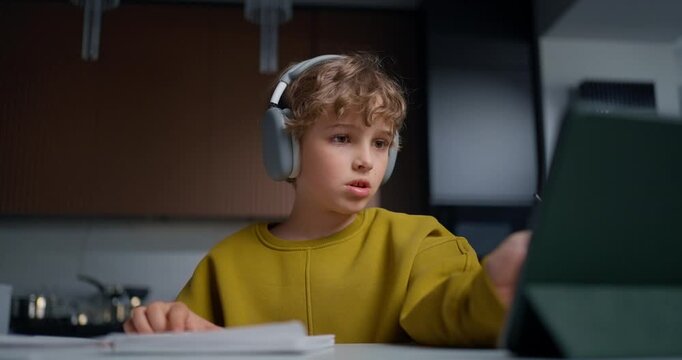 Young Male Student Concentrating On Electronic Coursework While Following Virtual Tutor Guidance