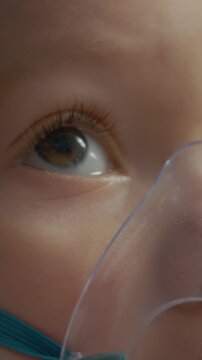 Vertical Screen: Child breathes in medicine through a mask connected to a nebulizer at home. This method helps treat respiratory infections like pneumonia with saline solution.