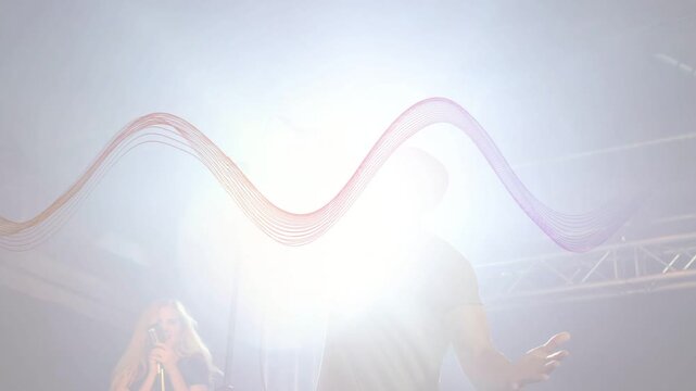 Lead singer singing onstage in music set, cue causing white flare, waveform pulsing around band