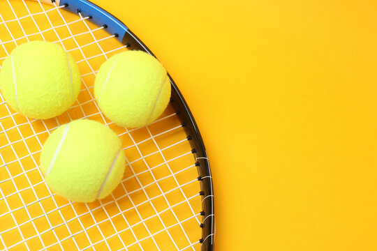 Large tennis court, balls and tennis racket on a yellow background