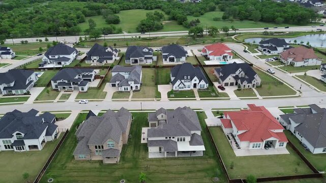 Mixed roof residential pattern west of Chinn Chapel Road highlights varied home designs bordering wooded edges and nearby pond in Copper Canyon. Roof textures, lawn gradients in Lantana, Texas