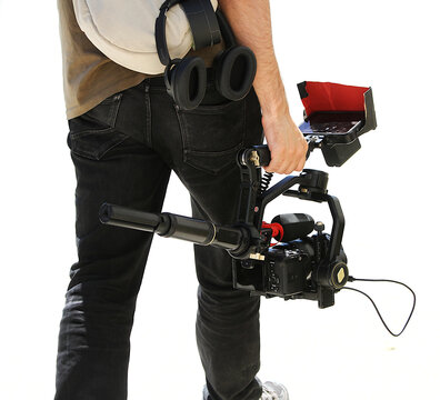 C&aacute;mara profesional de vide&oacute;grafo con empu&ntilde;adura y estabilizador gimbal de fotograf&iacute;a y v&iacute;deo m&oacute;vil de operador para creaci&oacute;n de contenido con tr&iacute;pode y cascos auriculares