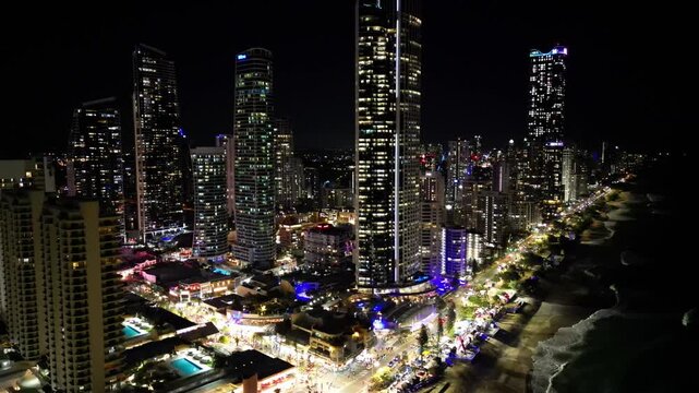 Aerial view of night cityscape of Gold Coast Queensland Australia. High rise buildings on the ocean shore with lights in the windows.