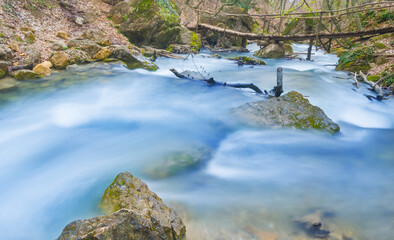 Fototapeta premium small river rushing over a stones in the mountain canyon