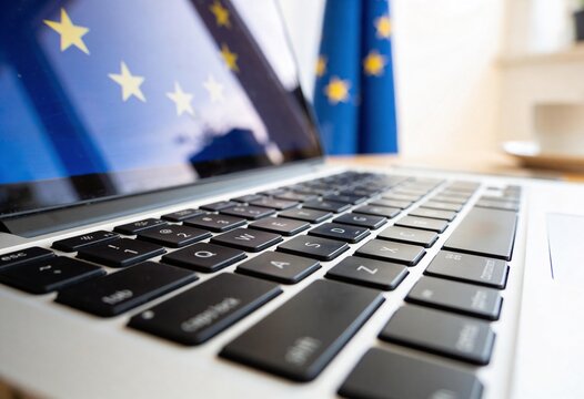 Close up of a laptop keyboard with the European Union flag displayed on the screen, representing digital policy and European law for technology and government regulation