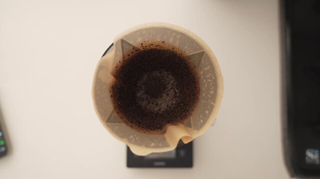 Overhead Pour-Over Coffee Dripper with Grounds in Paper Filter on Scale &ndash; 4K Video