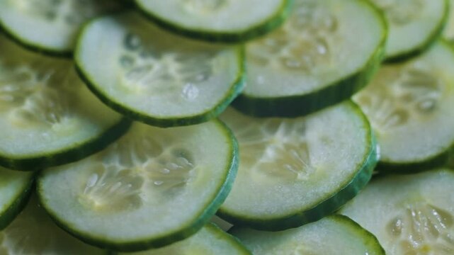 Cucumbers are cut into thin slices and arranged neatly to showcase their texture and color.