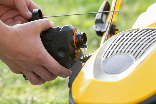 Pouring Oil Into Lawn Mower and Checking Oil Level &ndash; Small Engine Maintenance Close Up - Countryside Living and Outdoor Chores Lifestyle