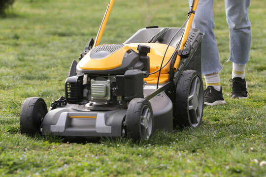 Woman Mowing Lawn in Rural Backyard &ndash; Countryside Living and Outdoor Chores Lifestyle