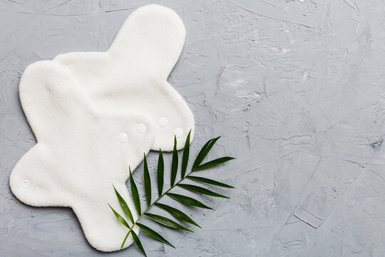 lean feminine sanitary napkin with green leaf. Absence of menstruation in woman. Minimal concept of female menopause. Copy space top view