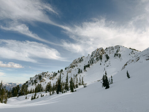Expansive snowy mountain landscape under dramatic cloud formations