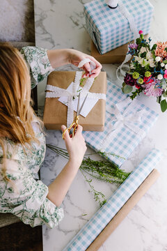 Woman wrapping rustic gift with ribbon