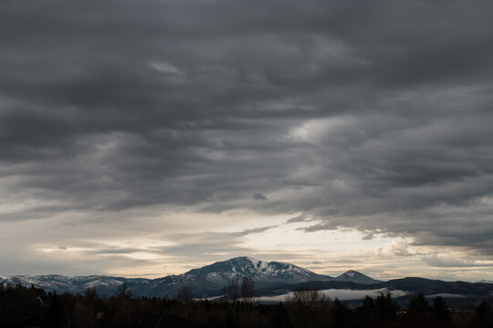 Dark storm clouds over distant snow-covered mountains in Utah